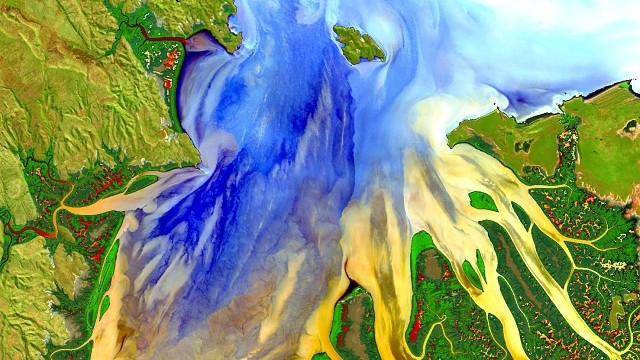 A colourful remotely-sensed image of a river delta